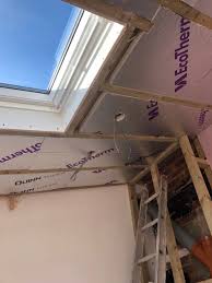 Roof window with insulated pitched ceiling lining inside a completed loft conversion in Hertfordshire